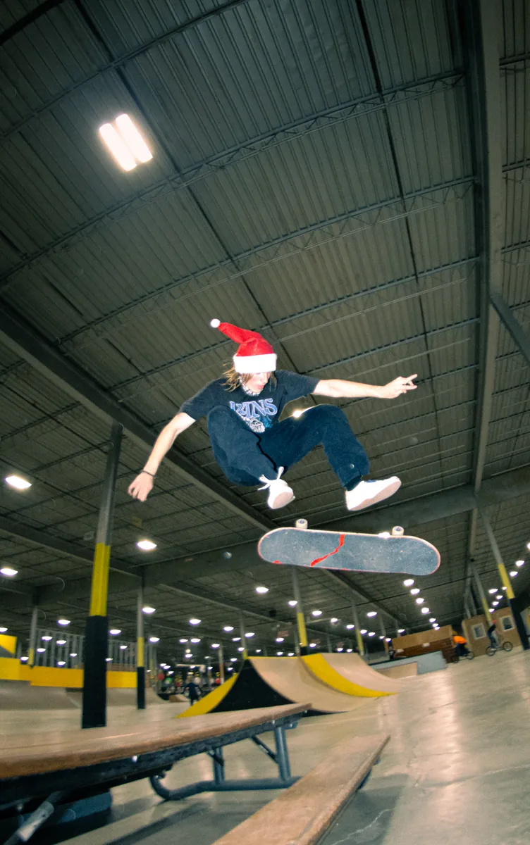 A skater in a Santa hat mid-air, separated from the board below them.