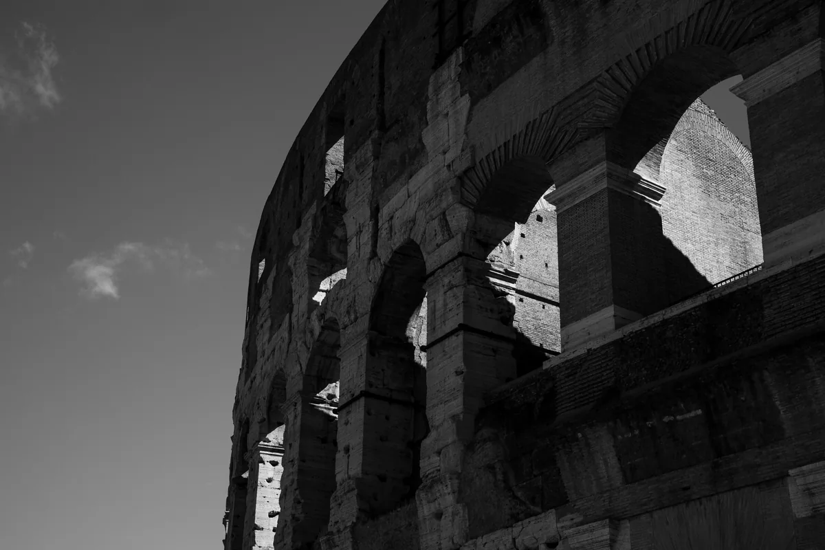 The tiered arches of the Colosseum's outer wall, Rome, in black and white.