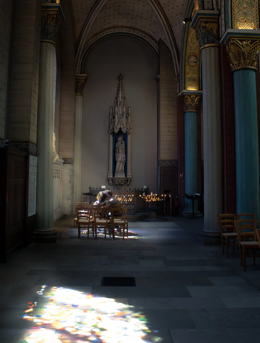 Colored light from stained glass falling across the stone floor of a church.