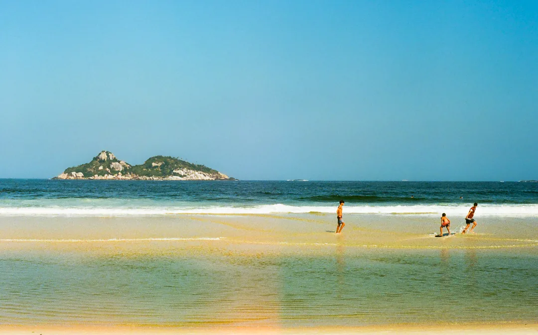 Bathers on a sandbar with a small island offshore, Fernando de Noronha.