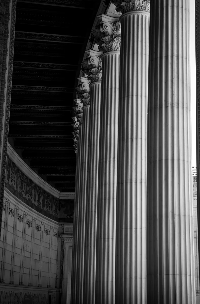 A row of fluted Corinthian columns seen at a steep angle from below.